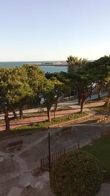 a park with benches and trees and the ocean at Casa Ensenada by 7Escalones in Rota
