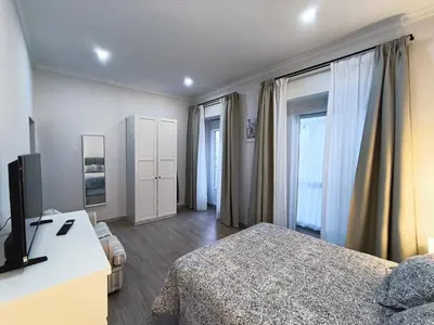 a bedroom with a bed and a desk with a television at Casa San Juan 55 - Centro Sanlúcar in Sanlúcar de Barrameda