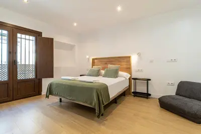 a bedroom with a bed and a couch at Allo Apartments Medina II Centro 1 Habitación in Jerez de la Frontera