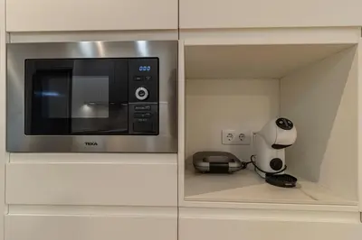 a microwave in a cabinet with a coffee maker and a coffee pot at Allo Apartments Medina II Centro 1 Habitación in Jerez de la Frontera