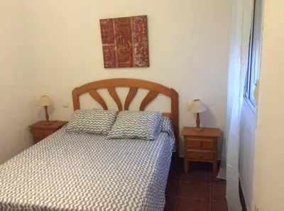 a bed with two pillows on it in a bedroom at Apartamento Urb Al Andalus A un paseo de la playa de la Barrosa in Novo Sancti Petri