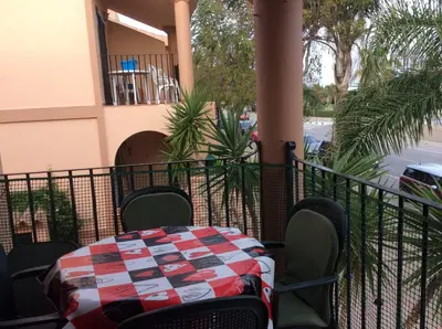 a table and chairs on the balcony of a house at Apartamento Urb Al Andalus A un paseo de la playa de la Barrosa in Novo Sancti Petri