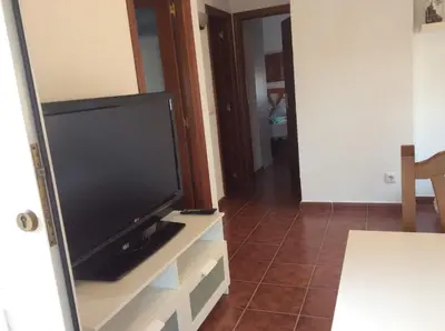 a flat screen tv sitting on top of a dresser at Apartamento Urb Al Andalus A un paseo de la playa de la Barrosa in Novo Sancti Petri