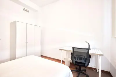 a bedroom with a bed and a desk and a chair at Cuca Rooms by Cadiz Time in Cádiz