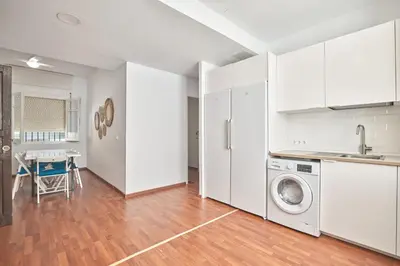 a kitchen with white cabinets and a washing machine at Cuca Rooms by Cadiz Time in Cádiz