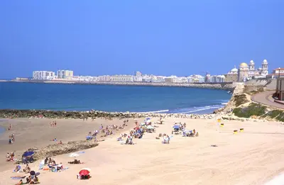a group of people on a beach near the ocean at Cuca Rooms by Cadiz Time in Cádiz
