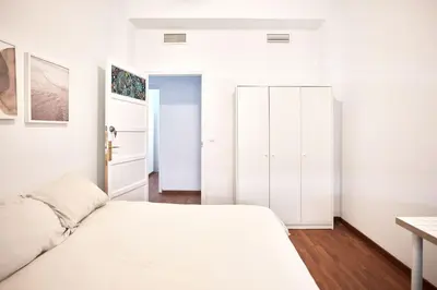 a white bedroom with a bed and a desk at Cuca Rooms by Cadiz Time in Cádiz