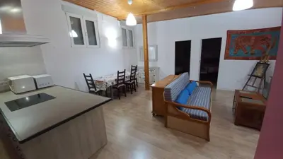 a kitchen and living room with a counter and chairs at Apartamento Alhaja in El Puerto de Santa María