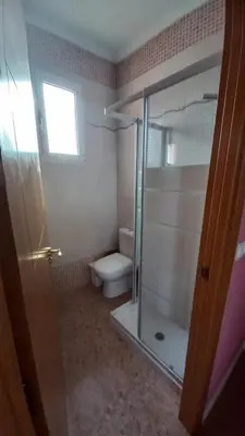 a bathroom with a toilet and a glass shower stall at Apartamento Alhaja in El Puerto de Santa María