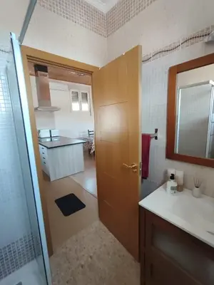 a bathroom with a sink and a door to a kitchen at Apartamento Alhaja in El Puerto de Santa María