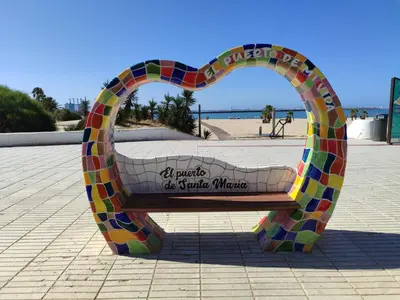 a bench in the shape of a heart on the beach at Apartamento Alhaja in El Puerto de Santa María