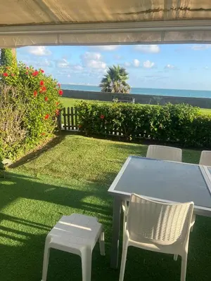 a patio with a table and chairs and the ocean at FUENTEBRAVIA playa MRZ RENTALS in El Puerto de Santa María