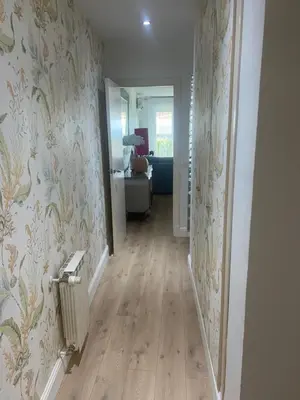 a hallway with a room with floral wallpaper at FUENTEBRAVIA playa MRZ RENTALS in El Puerto de Santa María