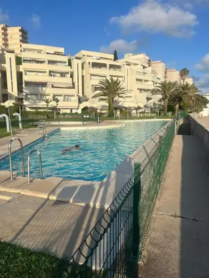 a swimming pool in front of a large building at FUENTEBRAVIA playa MRZ RENTALS in El Puerto de Santa María