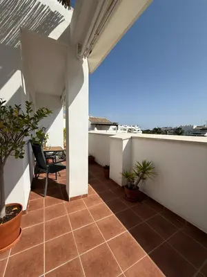 an outdoor patio with a tile floor and white walls at Ático Sabina free parking by staycare in Rota