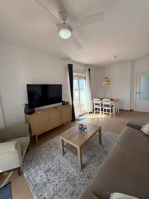a living room with a couch and a tv and a table at Ático Sabina free parking by staycare in Rota
