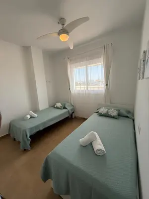 a room with two beds and a ceiling fan at Ático Sabina free parking by staycare in Rota