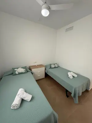 two beds in a room with towels on them at Ático Sabina free parking by staycare in Rota