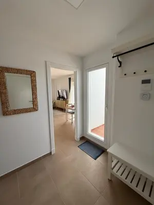 a living room with a large window and a mirror at Ático Sabina free parking by staycare in Rota