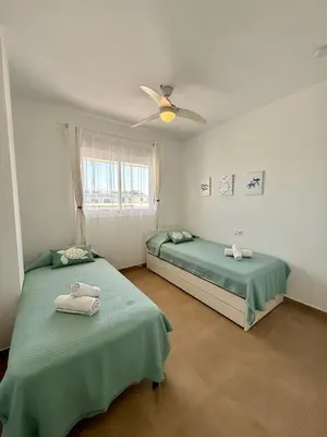 a bedroom with two beds and a ceiling fan at Ático Sabina free parking by staycare in Rota