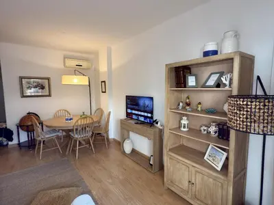 a living room with a table and a television and a room at Dúplex El Lago free parking by staycare in Rota