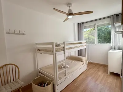 a white bunk bed in a room with a ceiling fan at Dúplex El Lago free parking by staycare in Rota