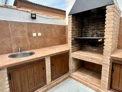 a kitchen with a sink and a brick wall at Modern 3-Bedroom Villa with Private Pool & BBQ in Cádiz