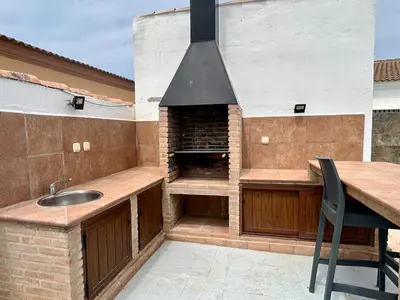 a outdoor kitchen with a sink and a stove at Modern 3-Bedroom Villa with Private Pool & BBQ in Cádiz