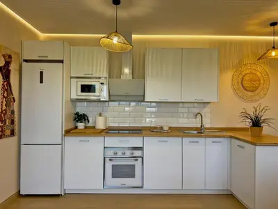 a kitchen with white cabinets and a white refrigerator at Casa Las Mironas II - Ole Solutions in El Puerto de Santa María