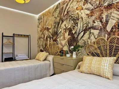 a bedroom with two beds and a wall mural at Casa Las Mironas II - Ole Solutions in El Puerto de Santa María