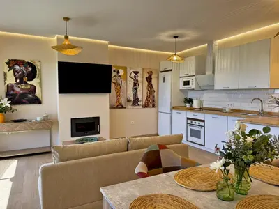 a kitchen and living room with a couch and a table at Casa Las Mironas II - Ole Solutions in El Puerto de Santa María