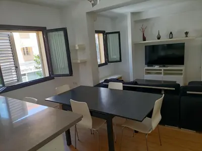 a living room with a black table and chairs at Góngora 2 in Chipiona