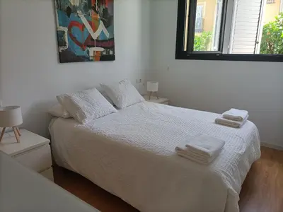 a bedroom with a white bed with towels on it at Góngora 2 in Chipiona