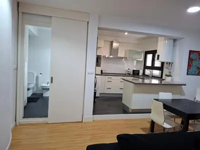 a kitchen and a dining room with a table and a kitchen at Góngora 2 in Chipiona