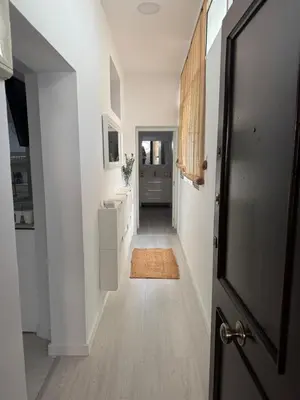 a hallway with white walls and a door to a room at Pleamar Apartamento in El Puerto de Santa María