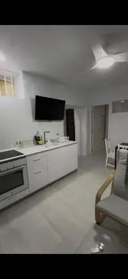 a white kitchen with a stove and a couch at Pleamar Apartamento in El Puerto de Santa María