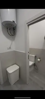 a white bathroom with a toilet and a sink at Pleamar Apartamento in El Puerto de Santa María