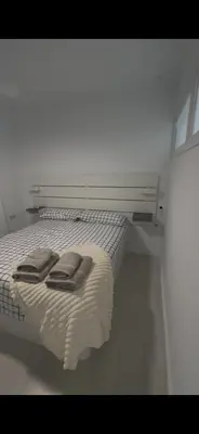 a bed with two towels on it in a room at Pleamar Apartamento in El Puerto de Santa María