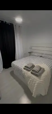 a bedroom with a bed with two towels on it at Pleamar Apartamento in El Puerto de Santa María