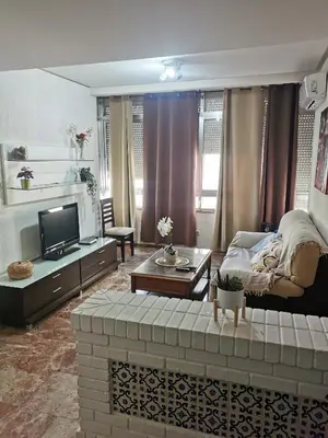 a living room with a couch and a tv at Se alquilan habitaciones in Jerez de la Frontera