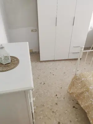 a room with a white table and a chair at Se alquilan habitaciones in Jerez de la Frontera
