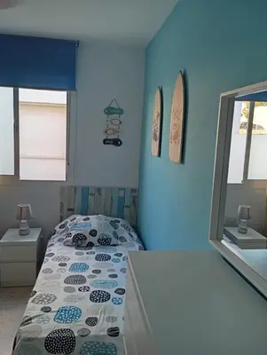 a bedroom with a bed and a blue wall at Villa León in Chipiona