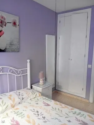 a bedroom with a bed and a closet and a cabinet at Villa León in Chipiona