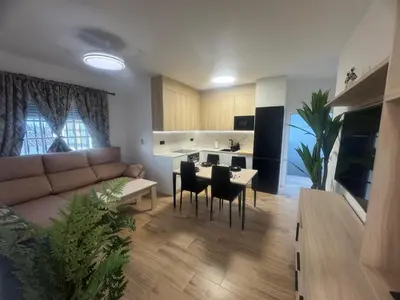a living room with a couch and a table and chairs at Ático Safari in Sanlúcar de Barrameda
