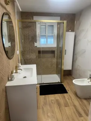 a bathroom with a shower and a sink and a mirror at Ático Safari in Sanlúcar de Barrameda