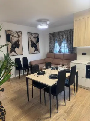 a dining room and living room with a table and chairs at Ático Safari in Sanlúcar de Barrameda