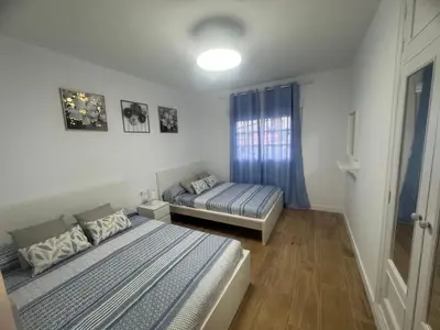 a bedroom with two beds and a window at Ático Safari in Sanlúcar de Barrameda