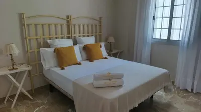 a bedroom with a large white bed with yellow pillows at Casa Tuca by 7Escalones in Rota