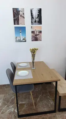 a wooden table with a vase of flowers on it at Casa Tuca by 7Escalones in Rota