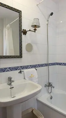 a bathroom with a sink and a mirror and a tub at Casa Tuca by 7Escalones in Rota